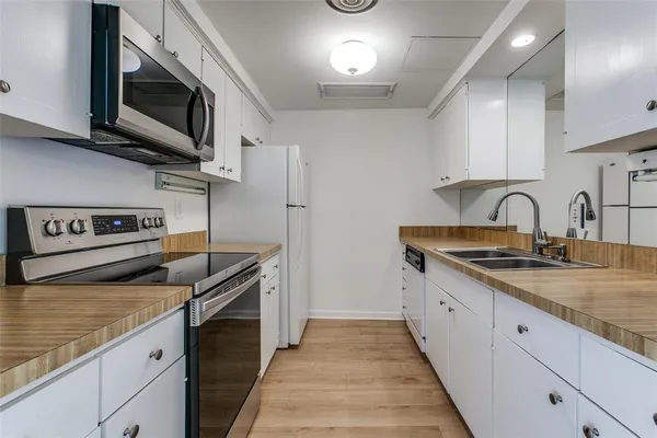 a kitchen with stainless steel appliances granite countertop a sink stove and microwave