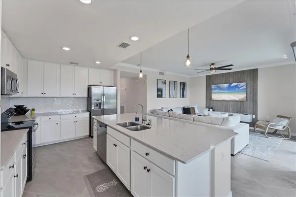 a kitchen that has a lot of cabinets a sink and appliances in it