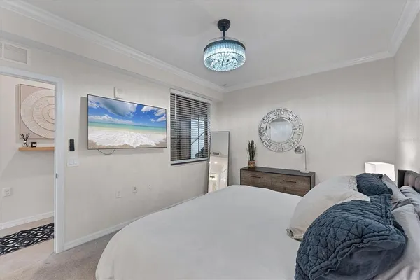 a bedroom with a bed and a chandelier