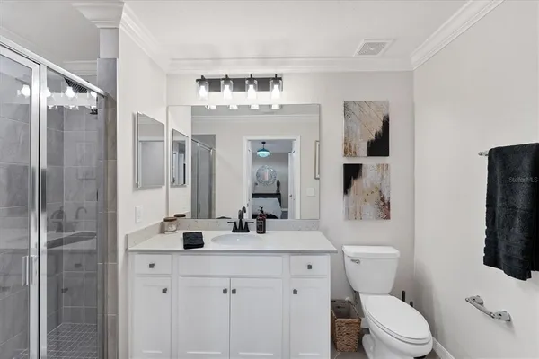 a bathroom with a sink a toilet a mirror and shower