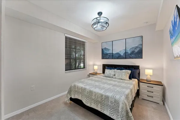 a bedroom with a bed and a chandelier