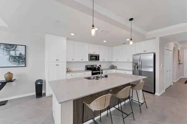 a kitchen with a dining table chairs refrigerator and microwave