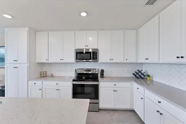 a kitchen with white cabinets and white appliances