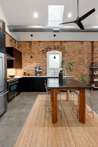 a large kitchen with stainless steel appliances a stove and a wooden floor