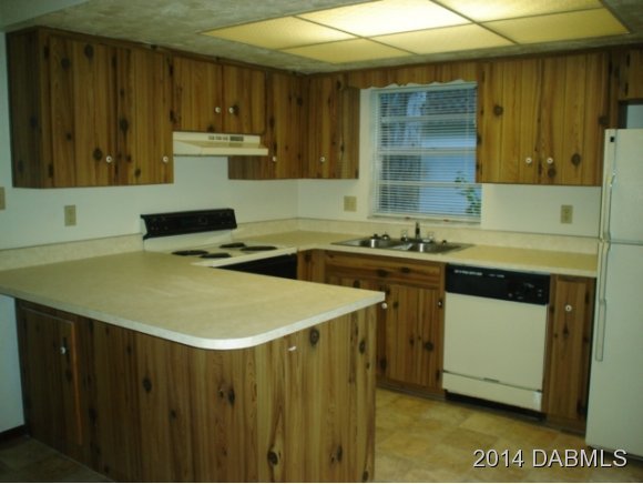 75 Springwood Square Port Orange, FL 32129 - Photo 2 of 6 a kitchen with a sink a stove and cabinets