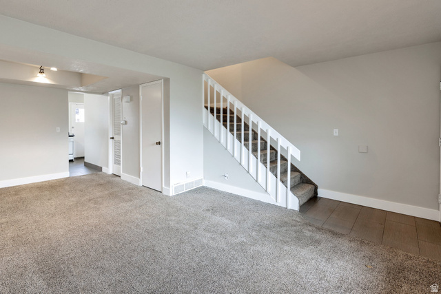 88 West 50 South, Unit J10 Centerville, UT 84014 - Photo 2 of 19 Living area with light gray carpeting, white baseboards, and a white staircase with carpeted treads