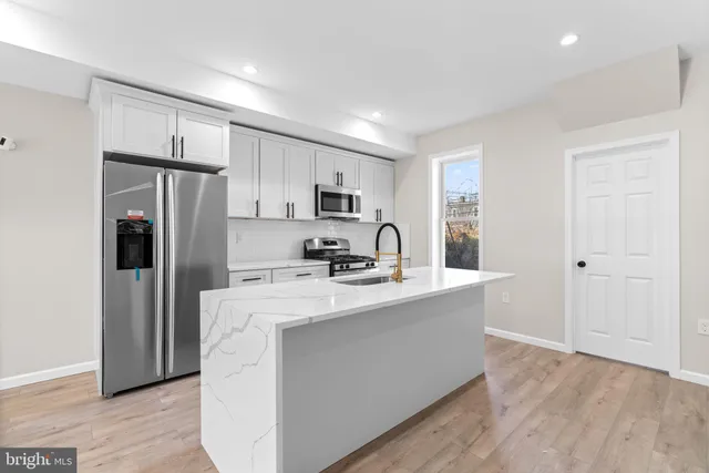 a kitchen with stainless steel appliances a refrigerator stove microwave and sink