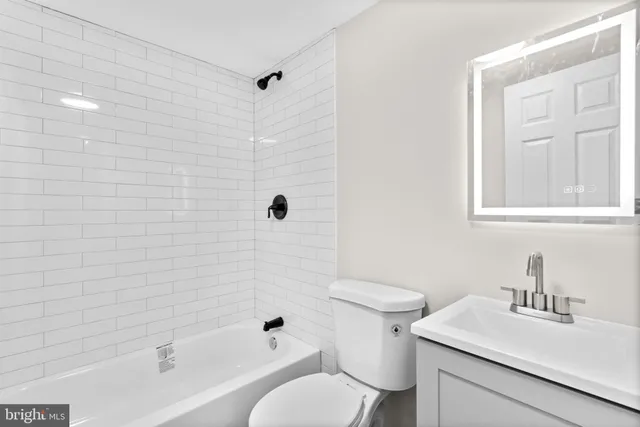 a bathroom with a sink toilet vanity and shower