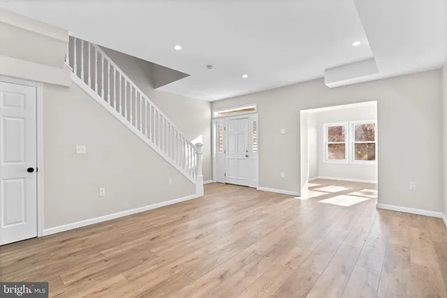 a view of an empty room with wooden floor and entryway