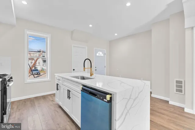 a kitchen with a sink a window and wooden floor