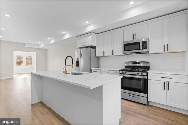 a kitchen with kitchen island a sink stainless steel appliances and cabinets