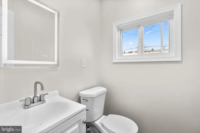 a bathroom with a toilet sink and mirror