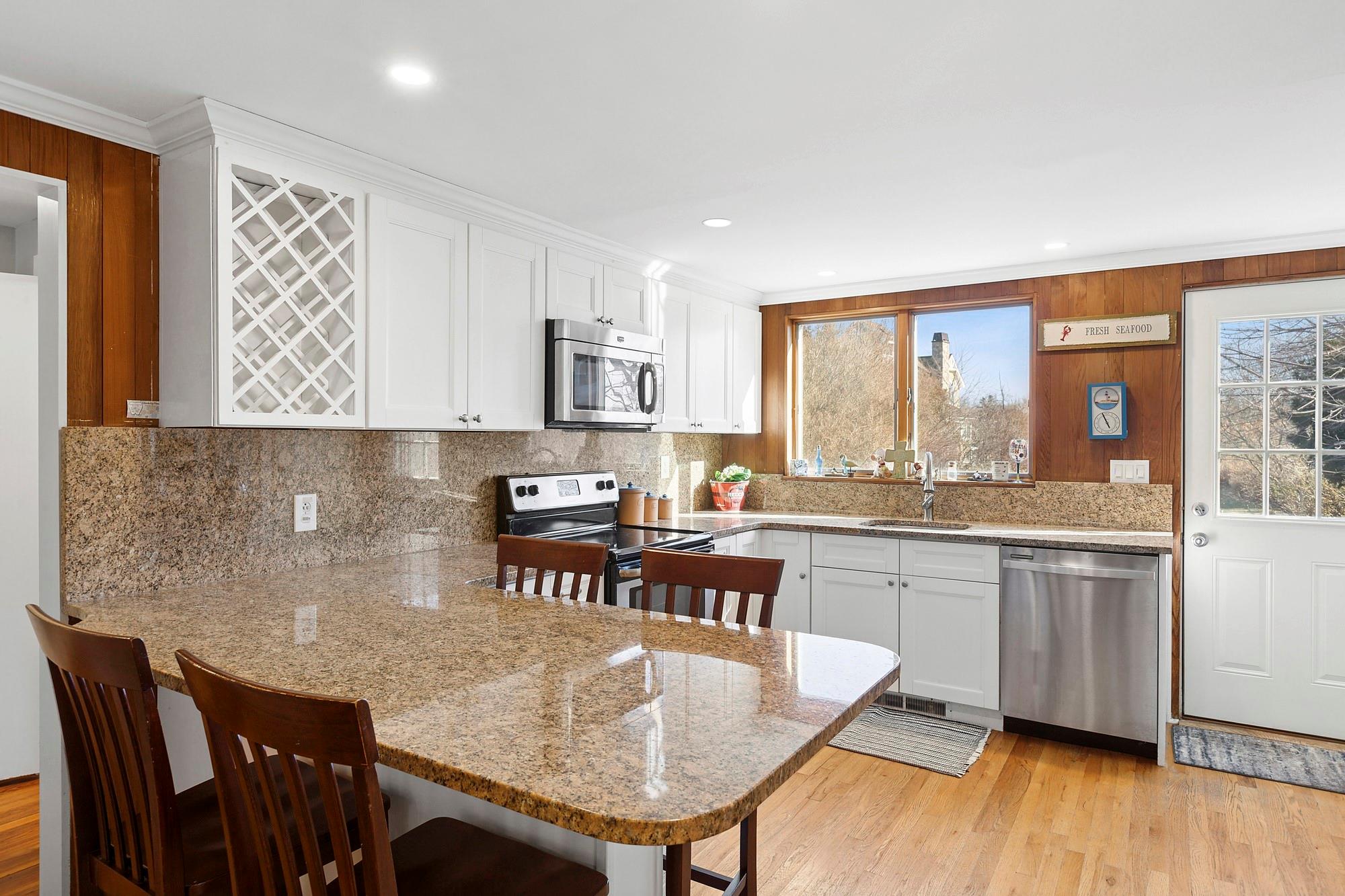 20 Mitchell Road Westhampton Beach, NY 11978 - Photo 7 of 16 a kitchen with granite countertop kitchen island stainless steel appliances a table and chairs in it