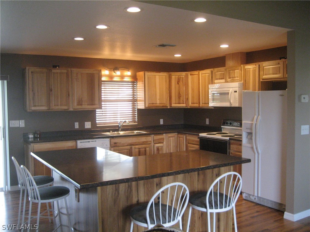18461 Geranium Road Fort Myers, FL 33967 - Photo 2 of 17 a kitchen with a dining table chairs and refrigerator