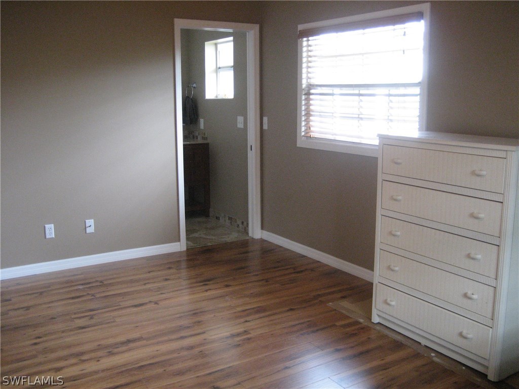 18461 Geranium Road Fort Myers, FL 33967 - Photo 8 of 17 an empty room with wooden floor closet and windows