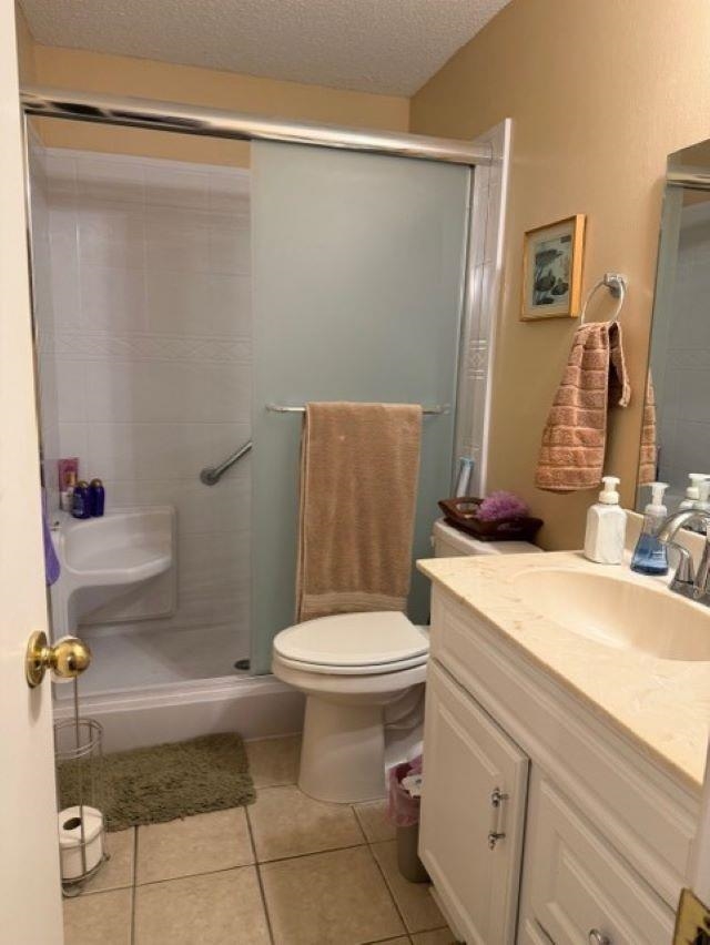 1099 Peyton Ridge Drive Collierville, TN 38017 - Photo 8 of 15 Full bathroom with vanity, a shower stall, light tile patterned floors, and a textured ceiling