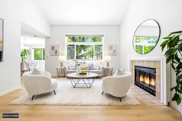 a living room with furniture a fireplace and a large window