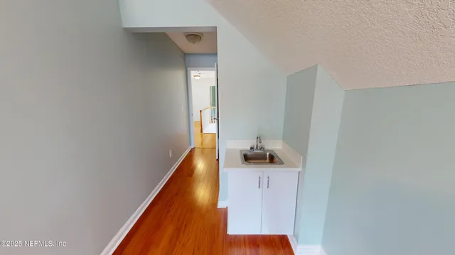 a view of hallway with wooden floor