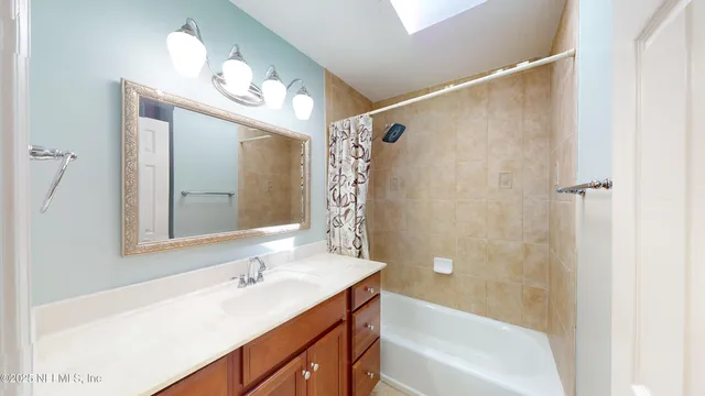 a bathroom with a tub sink and mirror