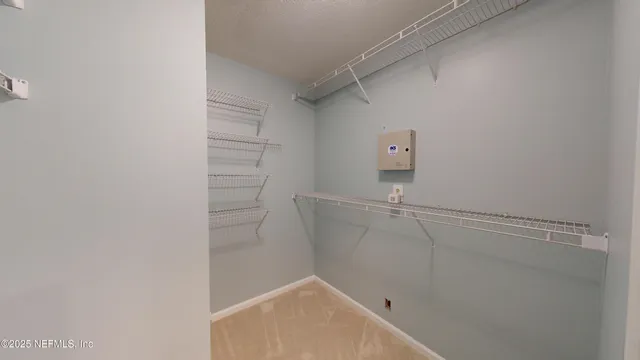 a view of walk in closet with empty racks