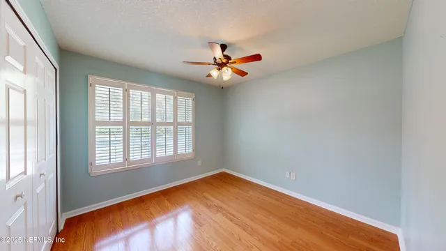 an empty room with a window and a fan