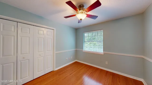 an empty room with window and ceiling fan