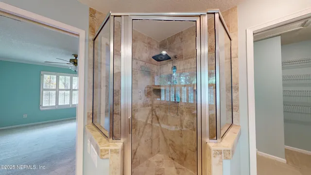 a bathroom with a glass shower door and a mirror