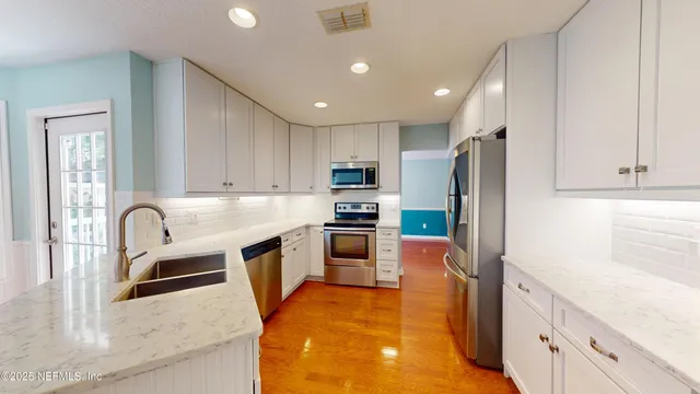 a kitchen with granite countertop a refrigerator and a sink