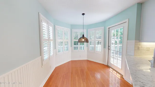 a view of a room with wooden floor and a chandelier
