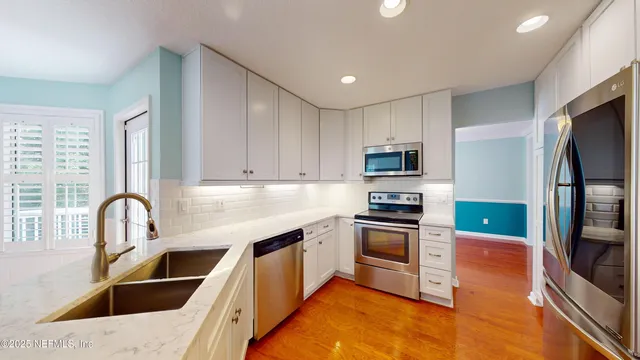 a kitchen with granite countertop a sink stainless steel appliances and counter space