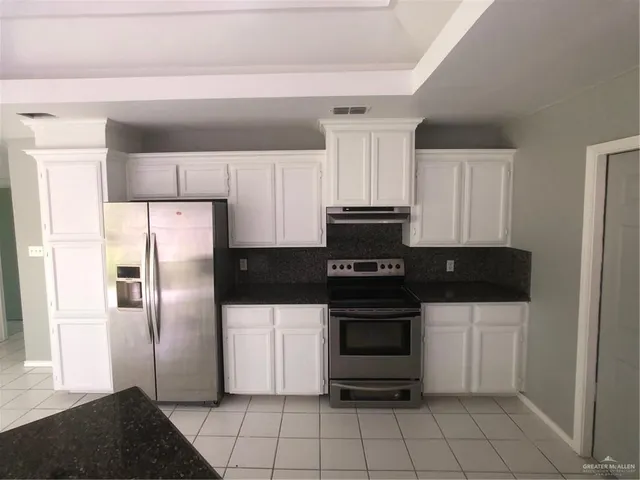 a kitchen with cabinets and stainless steel appliances