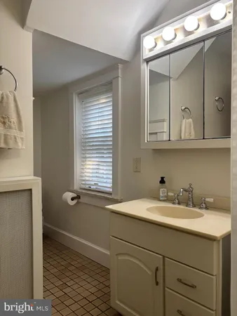 a bathroom with a sink and two mirror