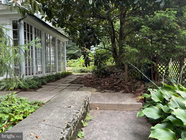 a pathway of a house with a garden