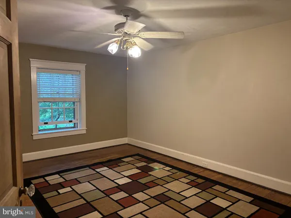 a view of a room with wooden floor and fan