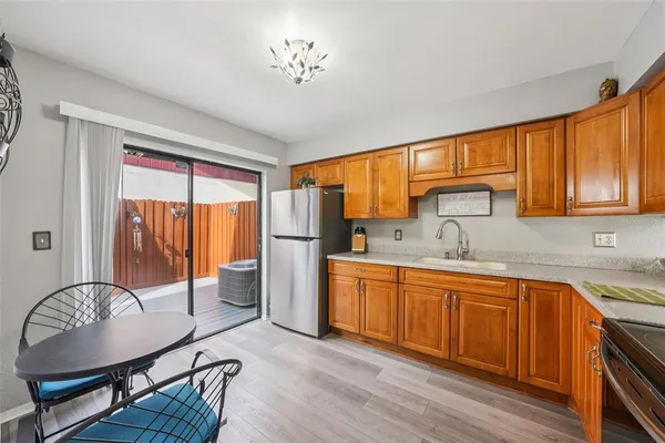 a view of a kitchen with a sink dishwasher a dining table and chair with wooden floor