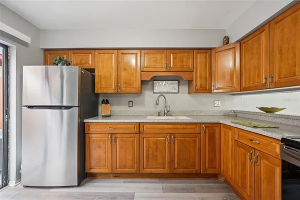 a kitchen with stainless steel appliances granite countertop a refrigerator and a sink