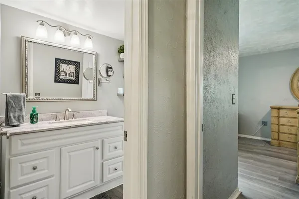 a bathroom with a granite countertop sink vanity mirror and a