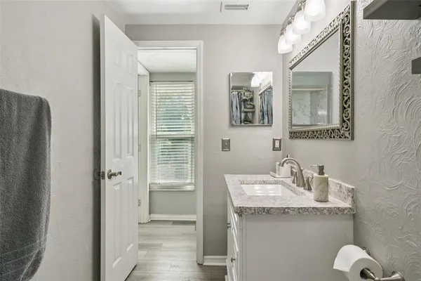 a bathroom with a granite countertop sink and a mirror