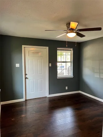 a view of a white house with large windows and a small yard