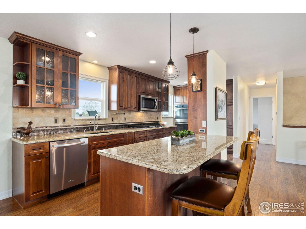 5100 Glen Drive Berthoud, CO 80513 - Photo 11 of 40 a kitchen with stainless steel appliances granite countertop a stove a sink a microwave a dining table and chairs