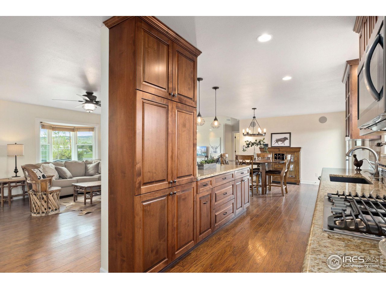5100 Glen Drive Berthoud, CO 80513 - Photo 13 of 40 a open kitchen with granite countertop a refrigerator cabinets wooden floor and a dining table