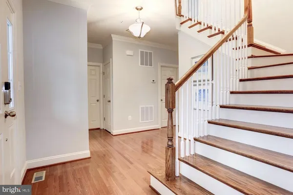 a view of staircase with wooden floor and a chandelier