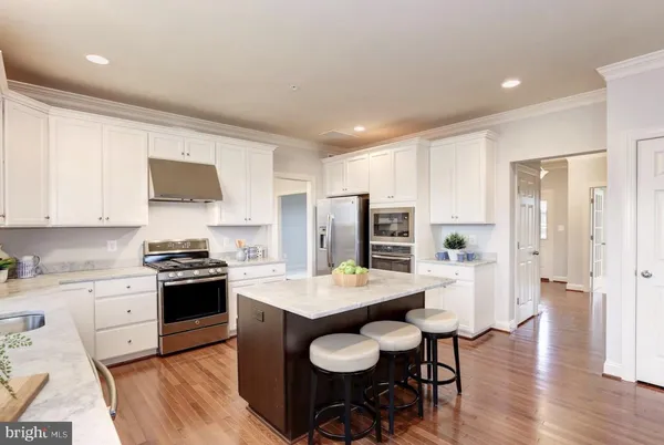 a kitchen with granite countertop a table chairs microwave and cabinets