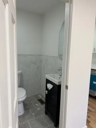 a bathroom with a granite countertop toilet and a sink