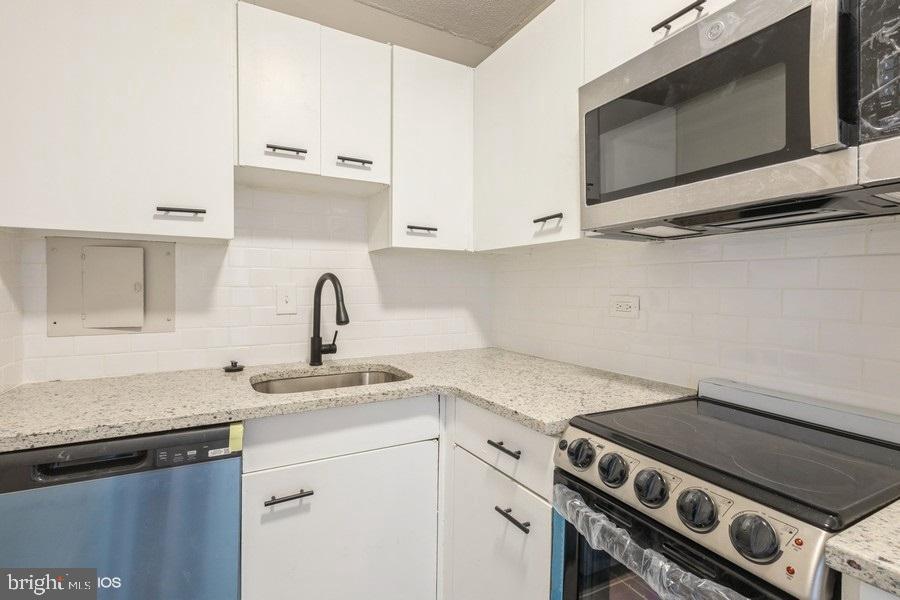 1301 Delaware Avenue Southwest, Unit N720 Washington, DC 20024 - Photo 11 of 20 a kitchen with stainless steel appliances granite countertop a sink stove and microwave