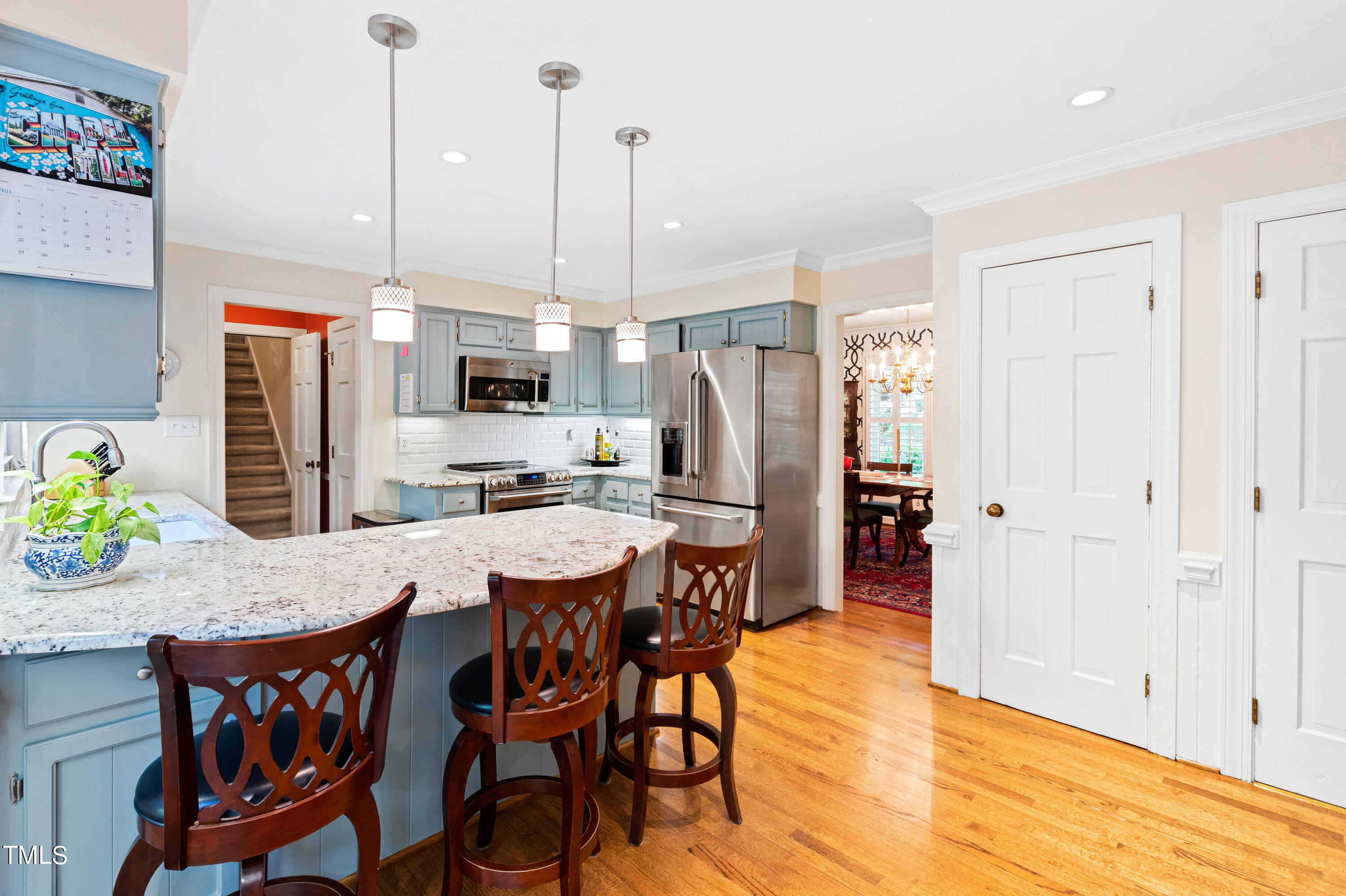 10212 Bushveld Lane Raleigh, NC 27613 - Photo 20 of 51 a view of a dining room and livingroom with furniture wooden floor a chandelier