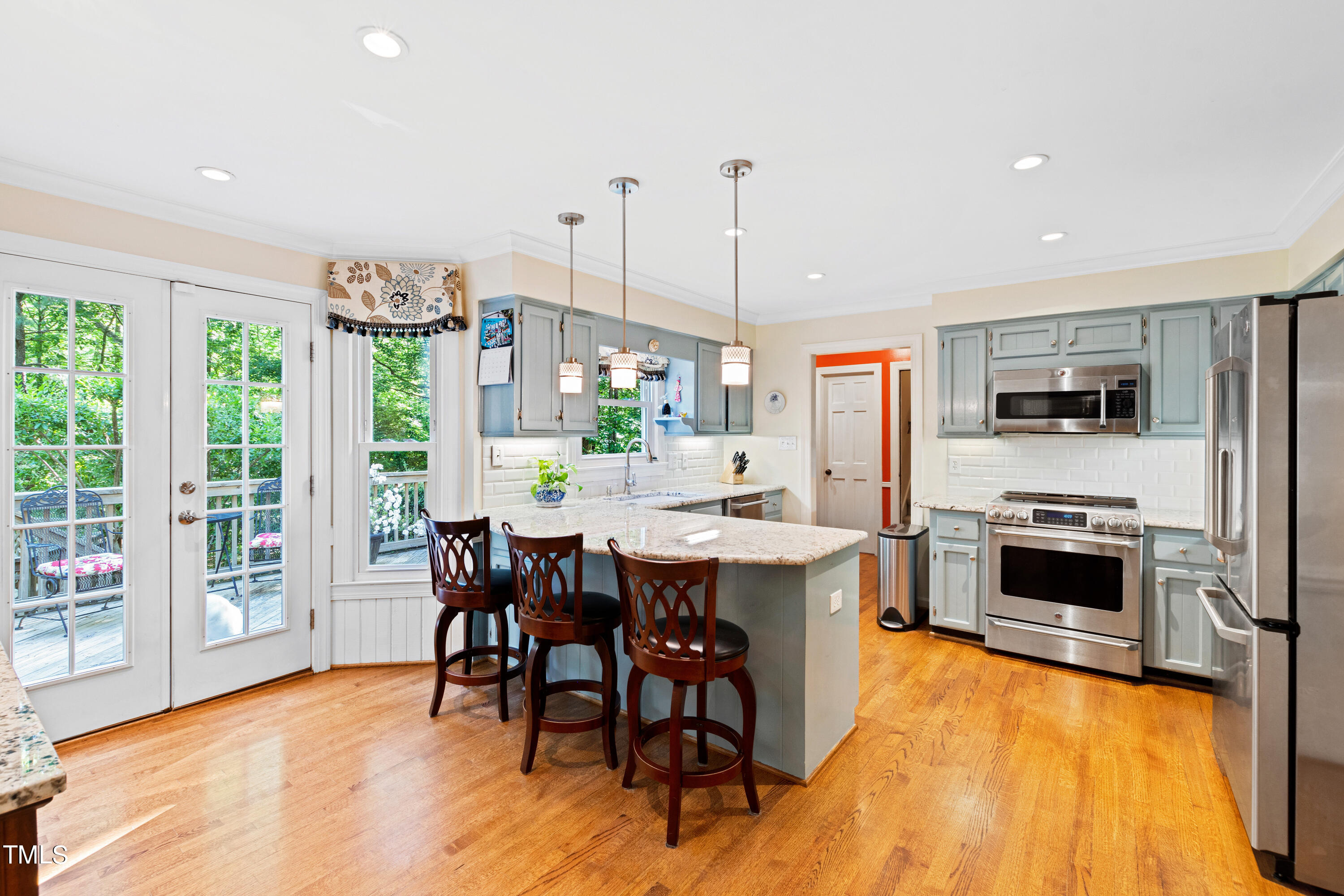 10212 Bushveld Lane Raleigh, NC 27613 - Photo 2 of 51 a open kitchen with stainless steel appliances granite countertop a stove top oven a sink dishwasher a dining table and chairs with wooden floor