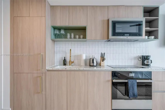 a kitchen with stainless steel appliances granite countertop a stove a microwave and wooden cabinets