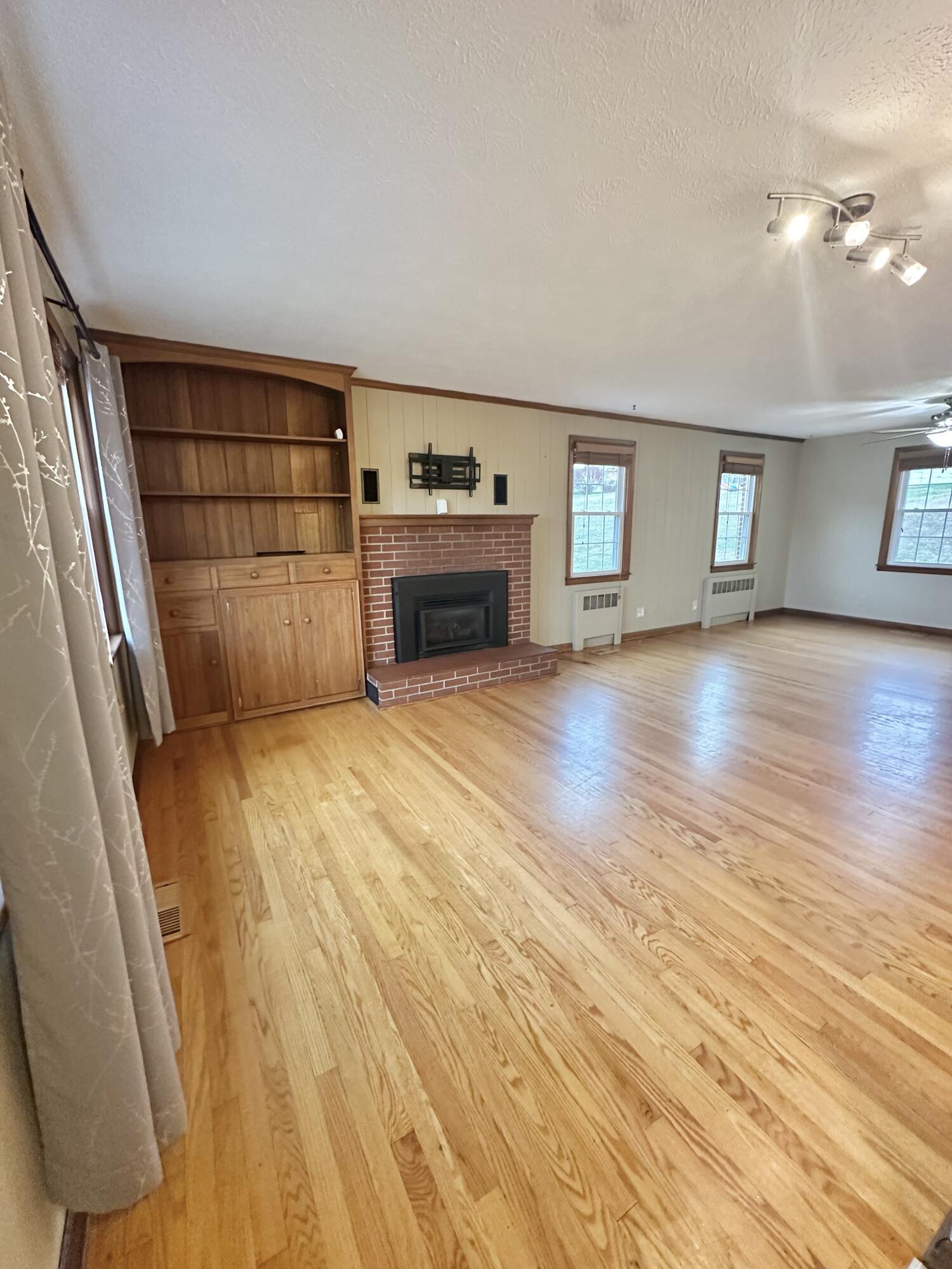 2714 Jackson River Road Covington, VA 24426 - Photo 20 of 54 wooden floor in an empty room with a fireplace