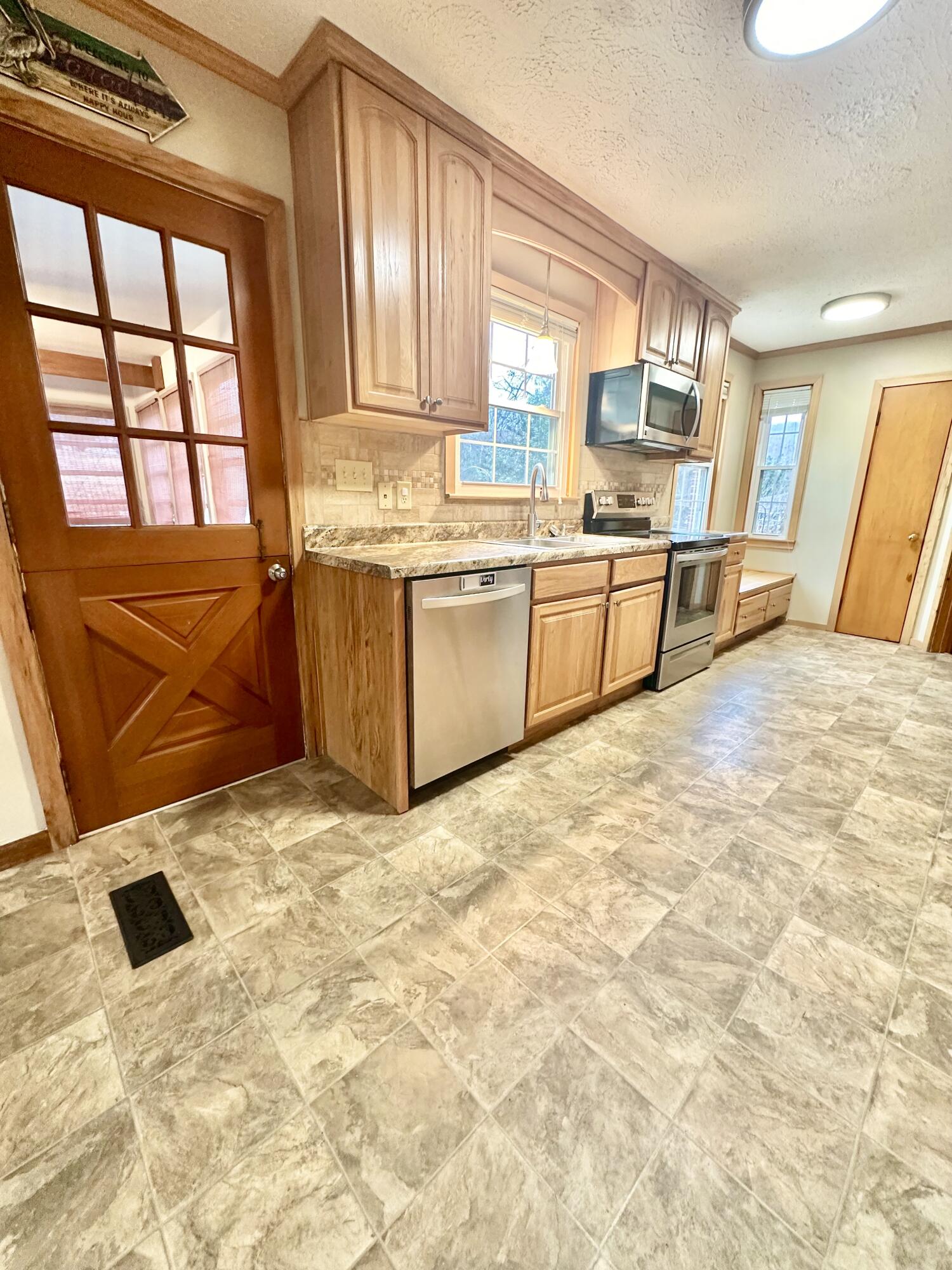 2714 Jackson River Road Covington, VA 24426 - Photo 26 of 54 a kitchen with granite countertop a stove a sink and a refrigerator